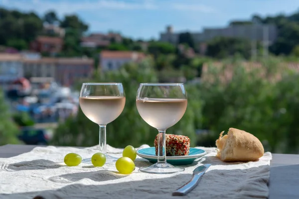 Rose wine of Provence, France, served cold with soft goat cheese on outdoor terrace in two wine glasses in sunny day