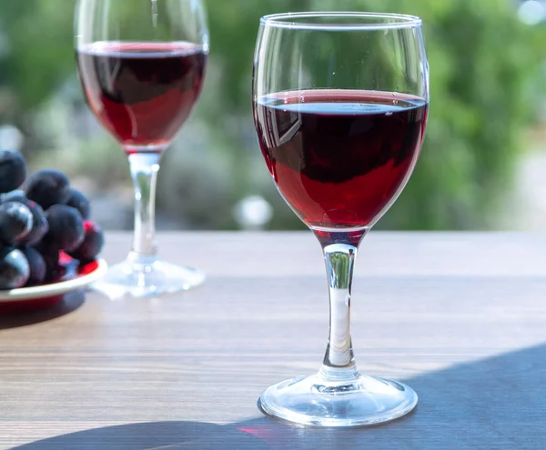 夏の晴れた日に屋外テラスで赤ワイン付きの2つのワイングラス — ストック写真