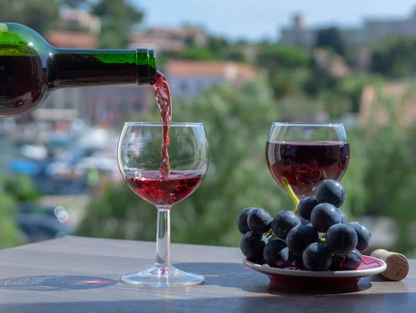 フランスの晴れた夏の日に屋外カフェテラスで赤ワインを注ぐウェイター — ストック写真