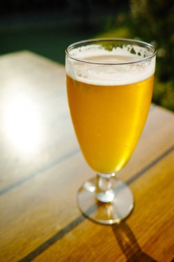 Bir soğuk ışık filtresiz cam içinde bira bahçedeki güneşli terasta servis edilir.