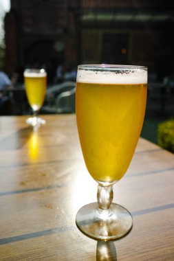 Bir soğuk ışık filtresiz cam içinde bira bahçedeki güneşli terasta servis edilir.