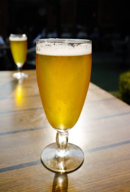 Bir soğuk ışık filtresiz cam içinde bira bahçedeki güneşli terasta servis edilir.