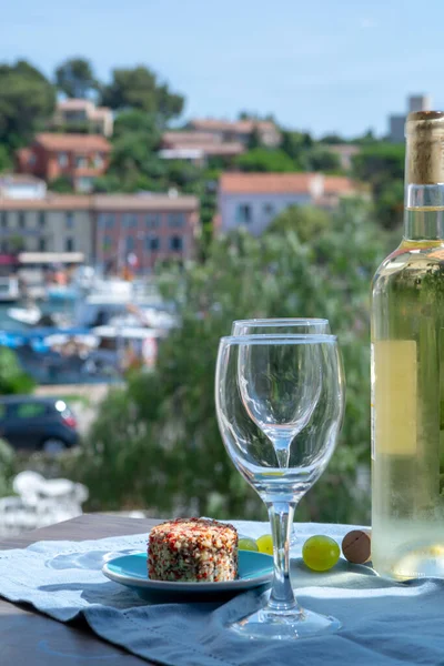 White wine of Provence, France, served cold with soft goat cheese on outdoor terrace in two wine glasses in sunny day
