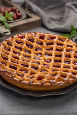 Ev yapımı açık vişneli turta, lezzetli tatlı gri masada servis edilir.