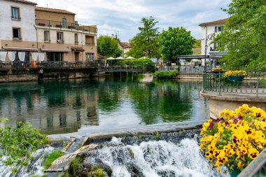 Turist ve tatil beldesi, Fransa 'nın güneyindeki Sotgue nehrinin yeşil suyuyla küçük Provencal kasabası lIsle-sur-la-Sorgue manzarası