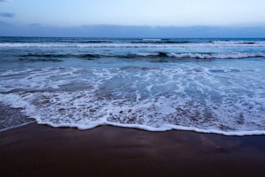 Mavi deniz suyu dalgaları ve kumlu sahil, deniz manzarası
