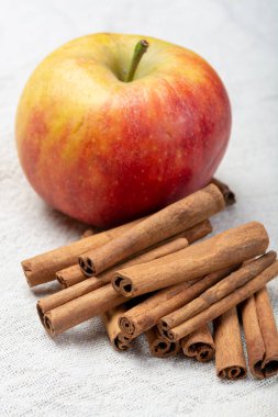 Kış pastası malzemeleri, kurutulmuş aromatik tarçın çubukları ve teneke tabakta elma.