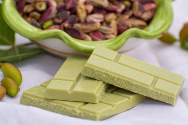 Tatlı, narin, mis kokulu fındıklar, parlak yeşil renkli bronte şam fıstığı ve yakın çekimde fıstıklı çikolata.