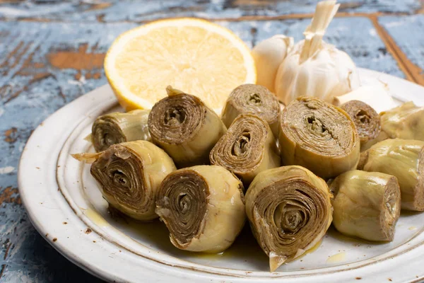 Marinated artichokes hearts with garlic, lemon and olive oil close up