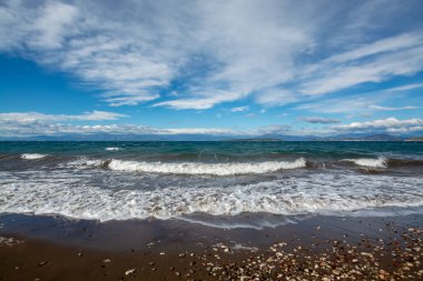 Su dalgaları ve Yunanistan 'ın Mora Dağları manzaralı dramatik renkli deniz manzarası