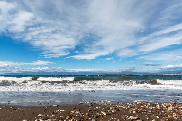 Su dalgaları ve Yunanistan 'ın Mora Dağları manzaralı dramatik renkli deniz manzarası