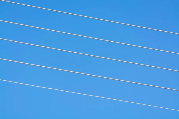 Empty music staff concept photo of 5 electric wires on blue sky, music creation template copy space