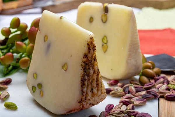 意大利产乳酪 意大利产乳酪或意大利产乳酪 与美味的绿色青铜开心果放在白色大理石盘上关闭 — 图库照片
