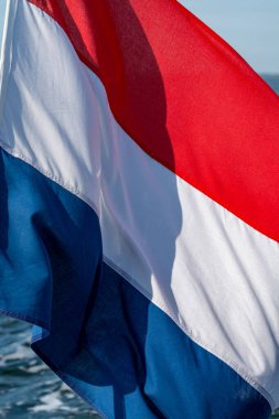 Deniz suyunun arka planında Hollanda kırmızı beyaz bayrağı