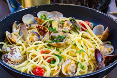 Deniz taraklı spagetti, tavada servis edilen makarna, yakın mesafede lezzetli İtalyan deniz ürünleri.