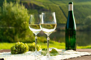 Almanya 'nın Mosel nehri vadisinde tepelerde büyüyen beyaz üzümlerden üretilen ünlü Alman kaliteli beyaz şarap şişesi Mosel Vadisi' nin dışında servis ediliyor.