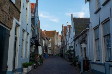 Hollanda 'nın küçük Goedereede kasabasında gün batımında eski evlerin olduğu sokak manzarası, Zeeland, Hollanda