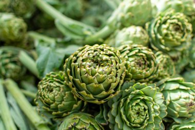 Enginar çiftliğinden taze çiğ enginar başları, Yunanistan 'ın Argolida kentindeki tarım pazarında yeni hasat.