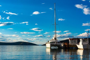 Sahil kıyısı ve büyük beyaz katamaran yatı, tatil yeri.