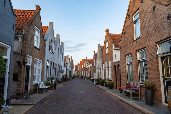 Street view with old houses in small Dutch town Goedereede on sunset, Zeeland, Netherlands