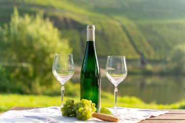 Almanya 'nın Mosel nehri vadisinde tepelerde büyüyen beyaz üzümlerden üretilen ünlü Alman kaliteli beyaz şarap şişesi Mosel Vadisi' nin dışında servis ediliyor.
