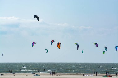 Su sporları etkinliği, renkli uçurtma sörfçüleri Kuzey Denizi 'nde Renesse, Zeeland, Hollanda yakınlarında yarışıyor.