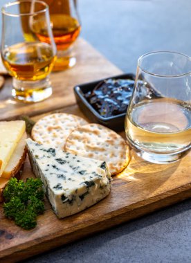 Viski ve peynir eşleşmesi, viski bardakları ve dilimlenmiş peynirli tabaklar.