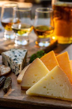 Viski ve peynir eşleşmesi, viski bardakları ve dilimlenmiş peynirli tabaklar.