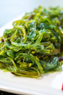 Taze yeşil oryantal yosun salatası. Yemek çubuklarıyla servis ediliyor.