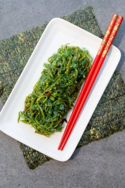 Taze yeşil oryantal yosun salatası. Yemek çubuklarıyla servis ediliyor.