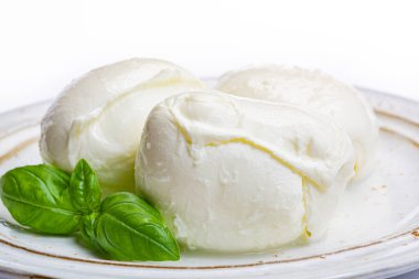 İtalyan yumuşak peyniri mozzarella, inek ya da bufalo sütünden yapılmış beyaz peynir taze yeşil fesleğenle kaplayın.