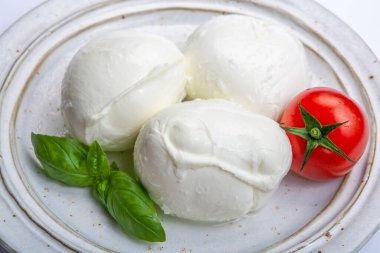 İtalyan yumuşak peyniri mozzarella, inek veya bufalo sütünden yapılmış beyaz peynir taze yeşil fesleğen otu ve kırmızı domates.
