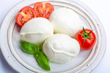 İtalyan yumuşak peyniri mozzarella, inek veya bufalo sütünden yapılmış beyaz peynir taze yeşil fesleğen otu ve kırmızı domates.