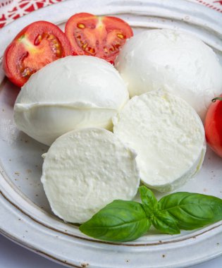 İtalyan yumuşak peyniri mozzarella, inek veya bufalo sütünden yapılmış beyaz peynir taze yeşil fesleğen otu ve kırmızı domates.