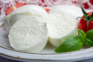İtalyan yumuşak peyniri mozzarella, inek veya bufalo sütünden yapılmış beyaz peynir taze yeşil fesleğen otu ve kırmızı domates.