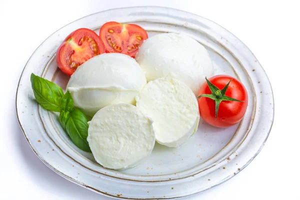 Italian soft cheese mozzarella, white cheese made from cow or buffalo milk with fresh green basil herb and red tomato close up