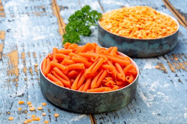 Mavi ahşap masada mercimekten yapılmış portakal glütensiz diyet makarna.