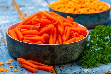 Mavi ahşap masada mercimekten yapılmış portakal glütensiz diyet makarna.