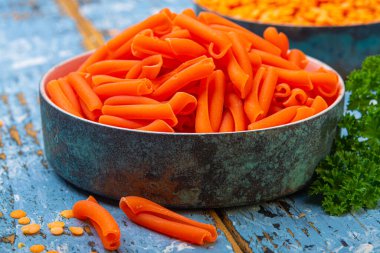 Mavi ahşap masada mercimekten yapılmış portakal glütensiz diyet makarna.