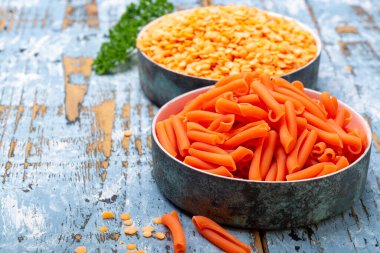 Mavi ahşap masada mercimekten yapılmış portakal glütensiz diyet makarna.