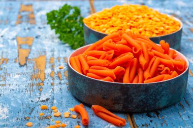 Mavi ahşap masada mercimekten yapılmış portakal glütensiz diyet makarna.