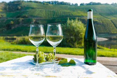 Almanya 'nın Mosel nehri vadisinde tepelerde büyüyen beyaz üzümlerden üretilen ünlü Alman kaliteli beyaz şarap şişesi Mosel Vadisi' nin dışında servis ediliyor.