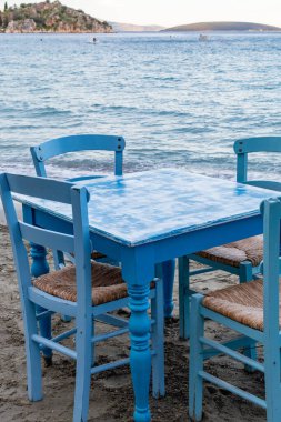 Suyun yakınındaki kumlu kumsalda turistleri bekleyen geleneksel Yunan tavernası Tolo, Moreloponese, Yunanistan 'da tatil sezonu başlıyor