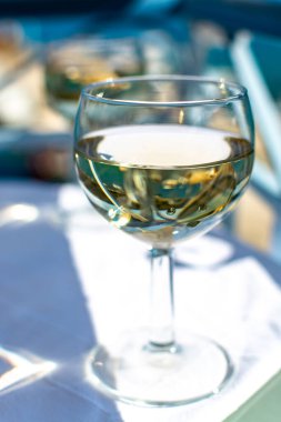 Balkonda servis edilen beyaz şarap cam masada, deniz manzaralı.