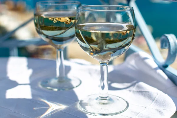 White wine served outside on balcony on glass table with sea view close up