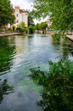Turist ve tatil beldesi, Fransa 'nın güneyindeki Sotgue nehrinin yeşil suyuyla küçük Provencal kasabası lIsle-sur-la-Sorgue manzarası