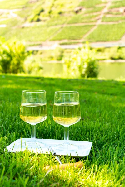 Tasting of famous German quality white wine riesling, produced in Mosel wine regio from white grapes growing on terraced vineyards in Mosel river valley in Germany
