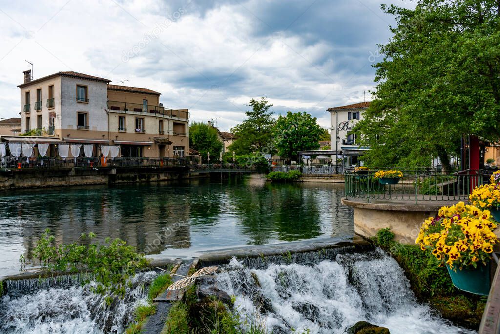 Tourist and vacation destination, view on small Provencal town lIsle-sur-la-Sorgue with green water of Sotgue river, South of France