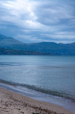 Alcamo Marina 'daki kumlu sahil üzerinde güneş doğarken gri-mavi bulutlar, İtalya' nın Sicilya kentinde küçük bir kasaba, yaz tatilinde tatil yeri.