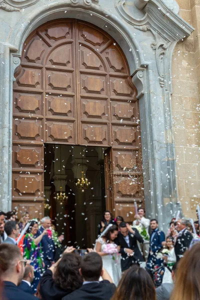 May 25, 2019, Marsala, Italy, Italian catholic wedding in church with many happy guests and salute from papers and rice